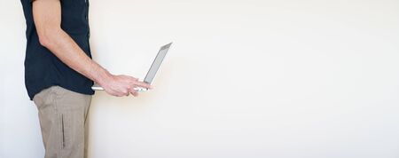 Male digital nomad hand holding a laptopの写真素材