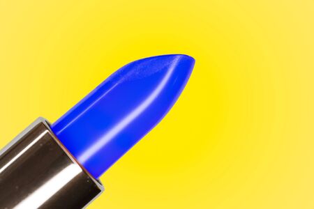 Beautiful bright classic blue lipstick and yellow complementary color on the backgroundの写真素材