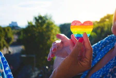 lesbian couple holding hands and a rainbow heartの写真素材