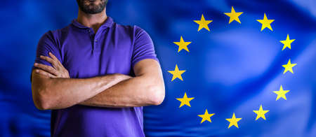 Torso of a man Young man with arms crossed against EU flagの写真素材