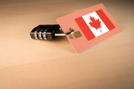 Padlock closed around a credit card with Canadian flagの写真素材