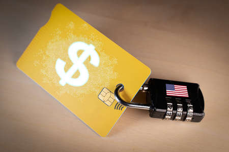 Padlock closed around a credit card with digital US dollar on itの写真素材
