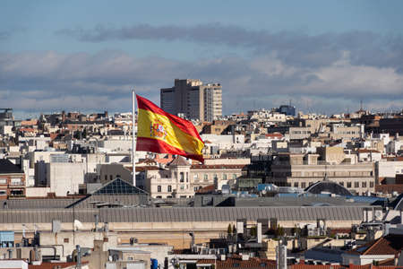 Giant spanish waving flag over the Madrid cityscapeの写真素材
