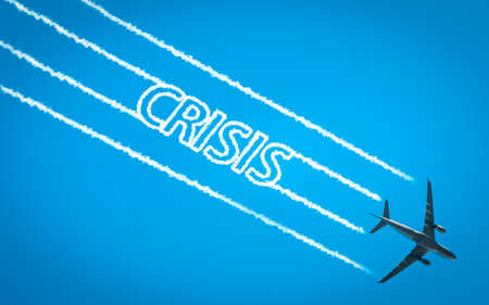 Airplane leaving jet contrails with Crisis word insideの写真素材