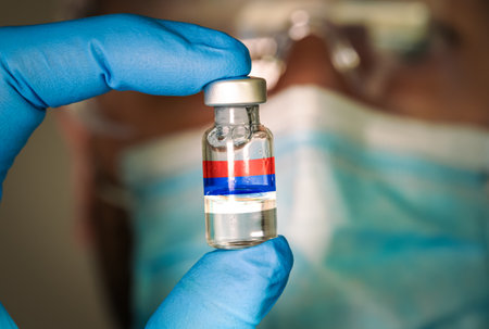Close-up of medical vial with the russian flag and blurred doctor on the background.の写真素材
