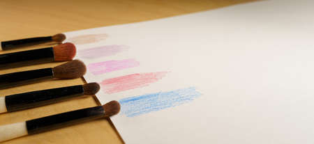 makeup brushes in a row on a paper with color swatchesの写真素材