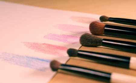 makeup brushes in a row on a paper with color swatchesの写真素材