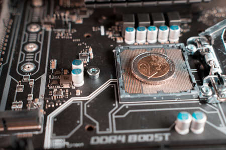 2 euro coin over a CPU slot in a motherboard, symbolizing the Digital Euro.の写真素材