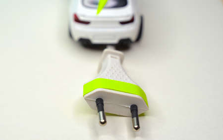 Toy car and electrical plug. Electric car and green car conceptの写真素材