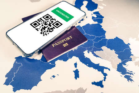 Digital green passport with QR code on a smartphone over an EU mapの写真素材