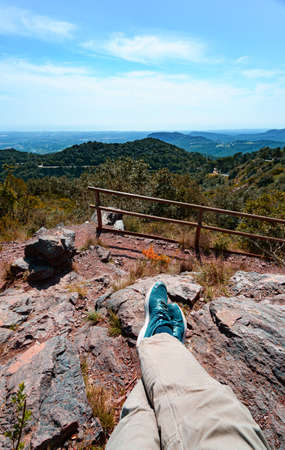 First person perspective shot from a hiker sitting Hiker sitting on top of a mountain at Argentera Ridge, catalonia, Spainの写真素材