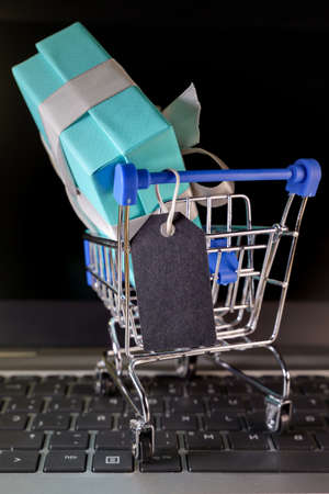 Small shopping cart with a gift inside and a Black tagの写真素材
