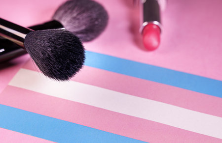 lipstick and make-up brushes close up view over a transgender flagの写真素材