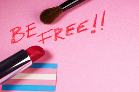 Be free expression with lipstick and make-up brushes close up view over a transgender flagの写真素材