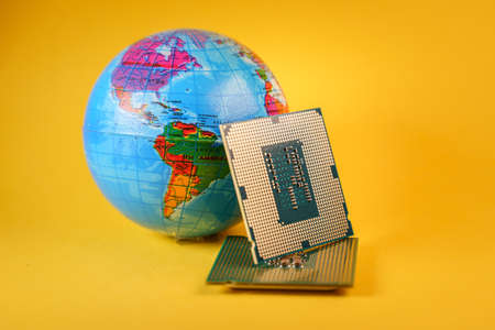 World globe and microprocessors against an orange backgroundの写真素材