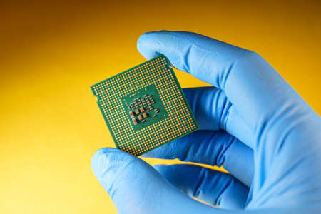 production of central processing units, gloved hand holds a cpuの写真素材