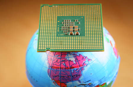 Selective focus of a CPU on top of a world globe against an orange backgroundの写真素材