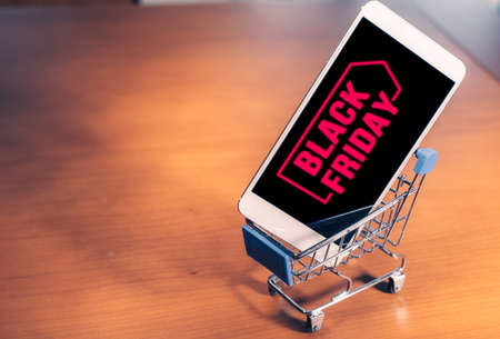 Smartphone with Black Friday on screen inside a small shopping cart, online shopping conceptの写真素材