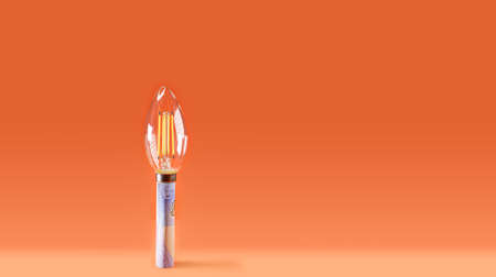 Led bulb on a euro bill, symbolizing the rising cost of electricity.の写真素材