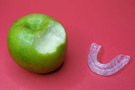 Green apple with bite and a dental splintの写真素材