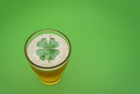 glass of beer with the silhouette of a 4 leaf clover in the foamの写真素材