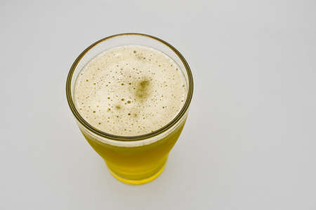 Glass of fresh and cold beer against a white backgroundの写真素材