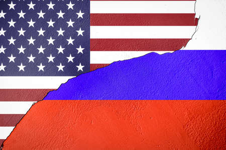 cracked painted wall with russia and USA flagsの写真素材