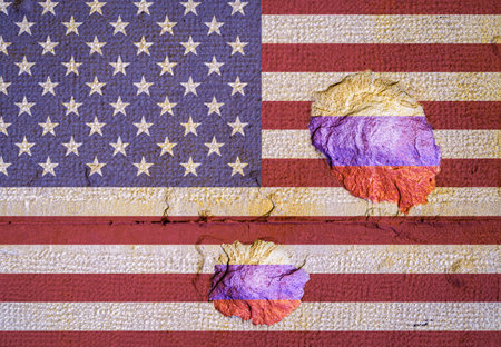 Bullet holes showing the flag of Russia on a rough wall with the flag of USAの写真素材