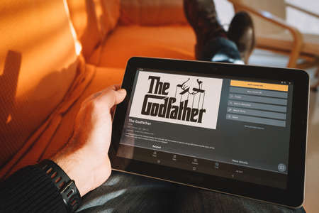 Tarragona, Spain. February 22: Man holding a tablet displaying the godfather movie on the streaming service amazon prime videoのeditorial素材