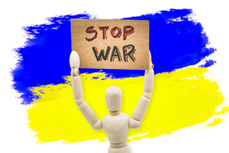wooden dummy holding a sign with the text Stop war.の写真素材