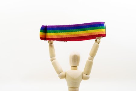 wooden mannequion holding a rainbow flag. Gay pride conceptの写真素材
