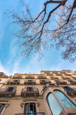 Bottom view of a building facade in Passeig de Gracia, Barcelona against a cloudy skyの写真素材