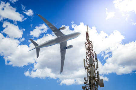 Mobile phone cell tower with 5G on the C Band frequencies with aircraft on the backgroundの写真素材