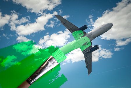 brush painting green an aircraft. Greenwashing malpractice, Zero emissions, SAF or Sustainable Aviation Fuel and biofuel concepts.の写真素材