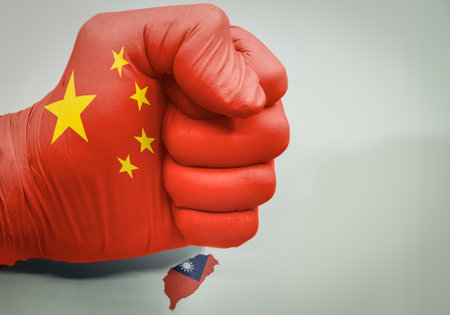 Fist with the colors of the flag of china crushing the island of taiwanの写真素材