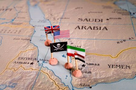 Flags of USA, UK, Iran and yemen surrounding the skull and crossbones pirate flag. The Red Sea Conflict Conceptの写真素材