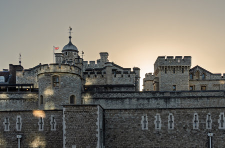 Tower of london walls rising at sunset with uk flag flyingの写真素材