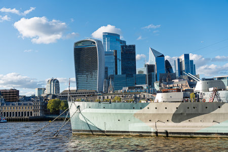 Hms belfast warship moored on river thames with cityscape in backgroundの写真素材