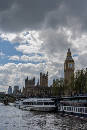 Pleasure boats cruising along river thames with big ben and houses of parliament in background, london, ukの写真素材
