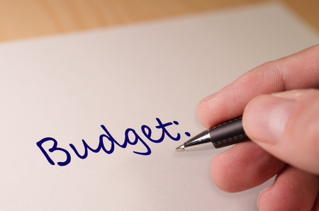 Accountant writing budget on white paper with penの写真素材