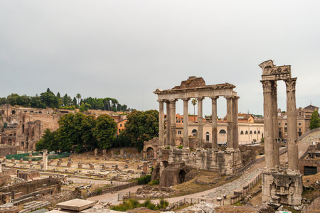 Roman Forum ancient ruins featuring Temple of Saturn columns in Rome Italy