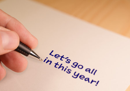Hand writing new year resolution goals on paper
