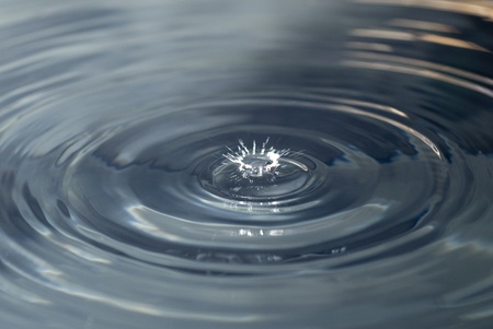 Macro photograph of drops falling to water.の写真素材