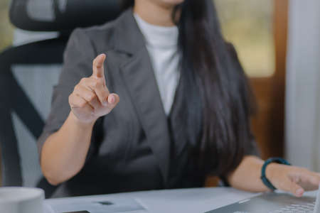 Businesswoman using finger for analysis maketing plan, Manager calculate financial report and graph chart. Business, Finance and Accounting conceptsの写真素材