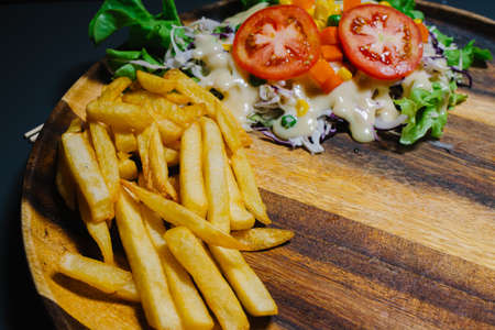 Grilled steak and lettuce, French fries on wooden plateの写真素材