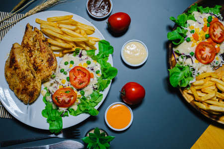 Grilled steak and lettuce, French fries on wooden plateの写真素材