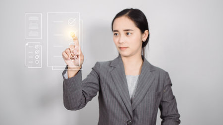 Business woman pressing a button on a touch screen interface. asianの写真素材
