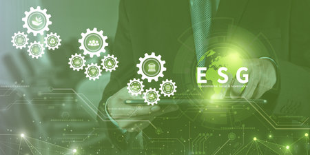 Businessman touching ESG icon on virtual screen for environmental, social, and governance in sustainable and ethical business on a technology green background.の写真素材