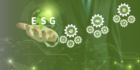 Businessman holding ESG icon on virtual screen for environmental, social, and governance in sustainable and ethical business on a technology green background.の写真素材