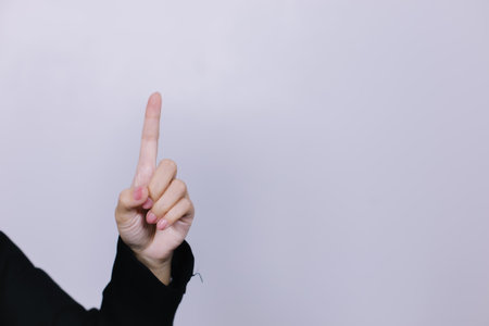 Businesswoman hand pointing finger up on white background with copy space.の写真素材